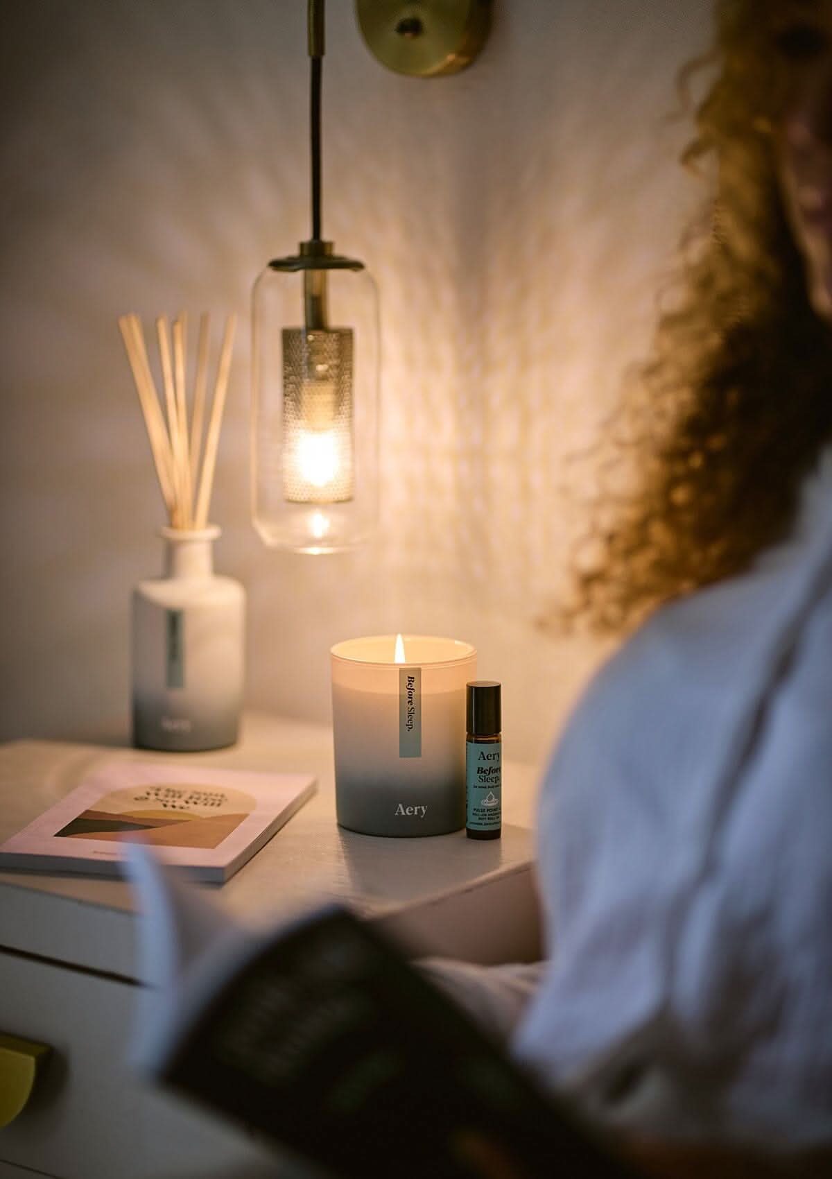 Blue Before Sleep pulse point oil displayed next to Before Sleep candle and diffuser by Aery on bedside table