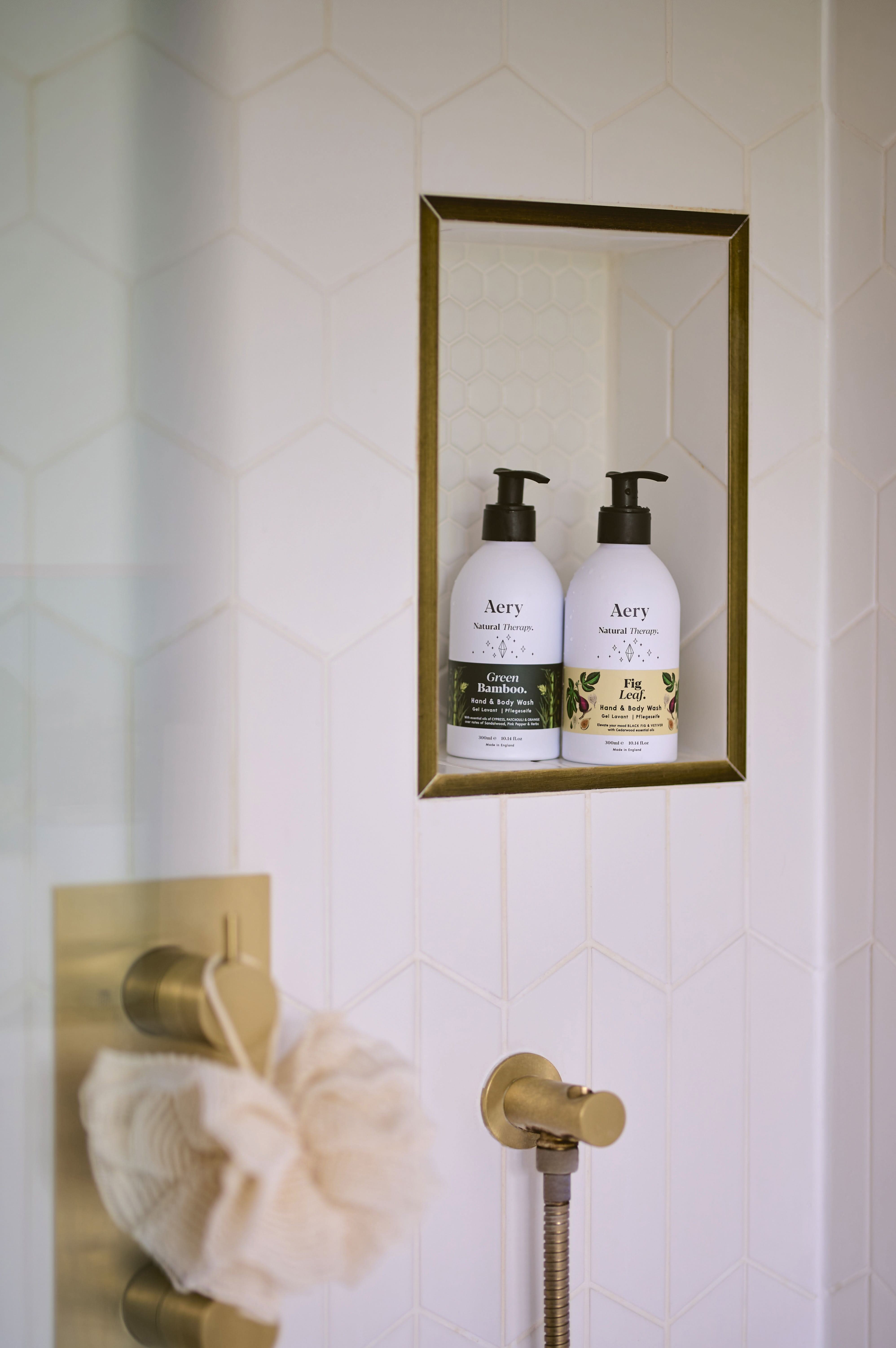Green Bamboo hand wash By Aery displayed next to Fig Leaf hand wash by Aery on shelf in shower
