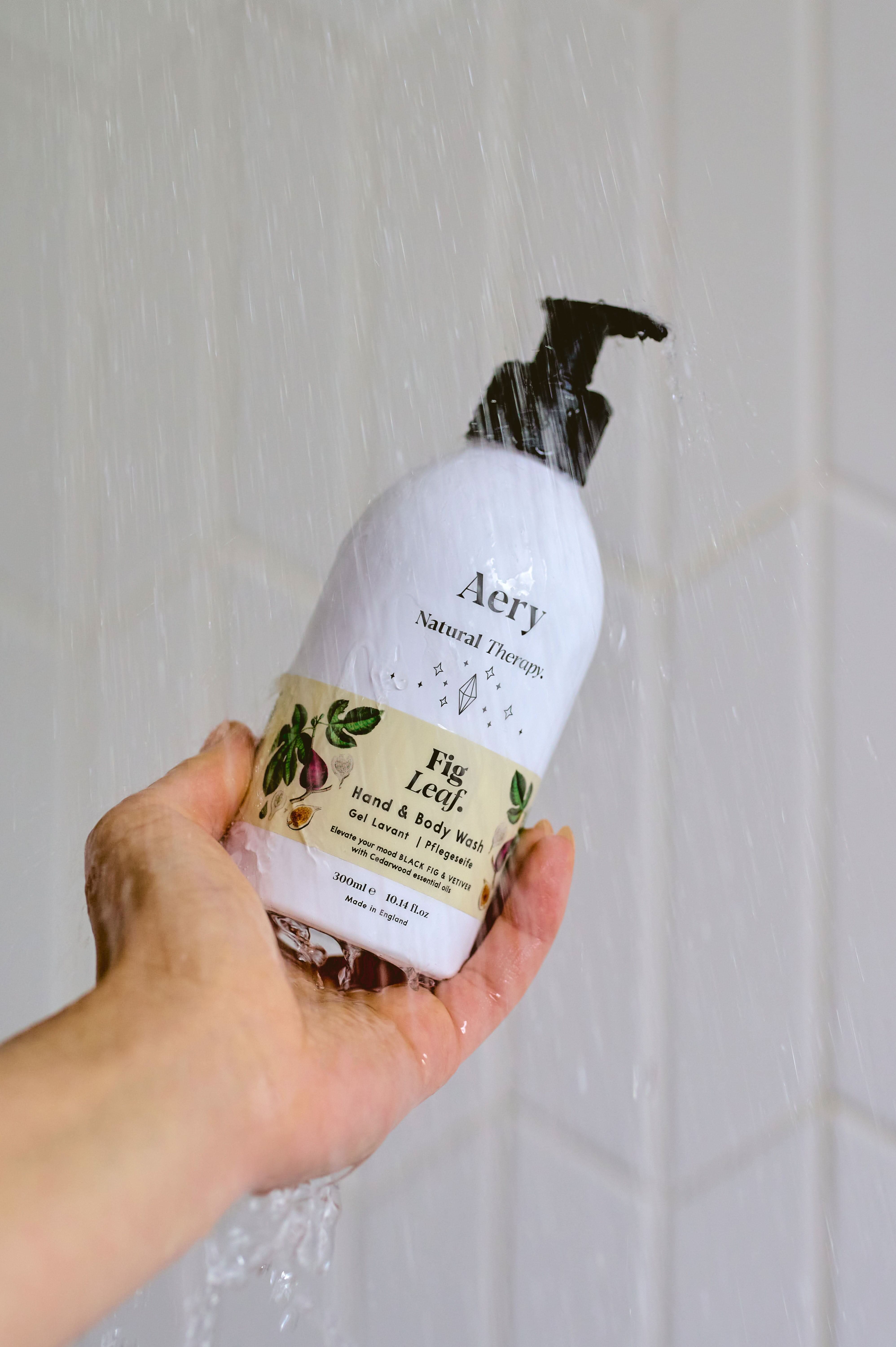 Cream Fig Leaf hand and body wash by Aery displayed in hand in shower