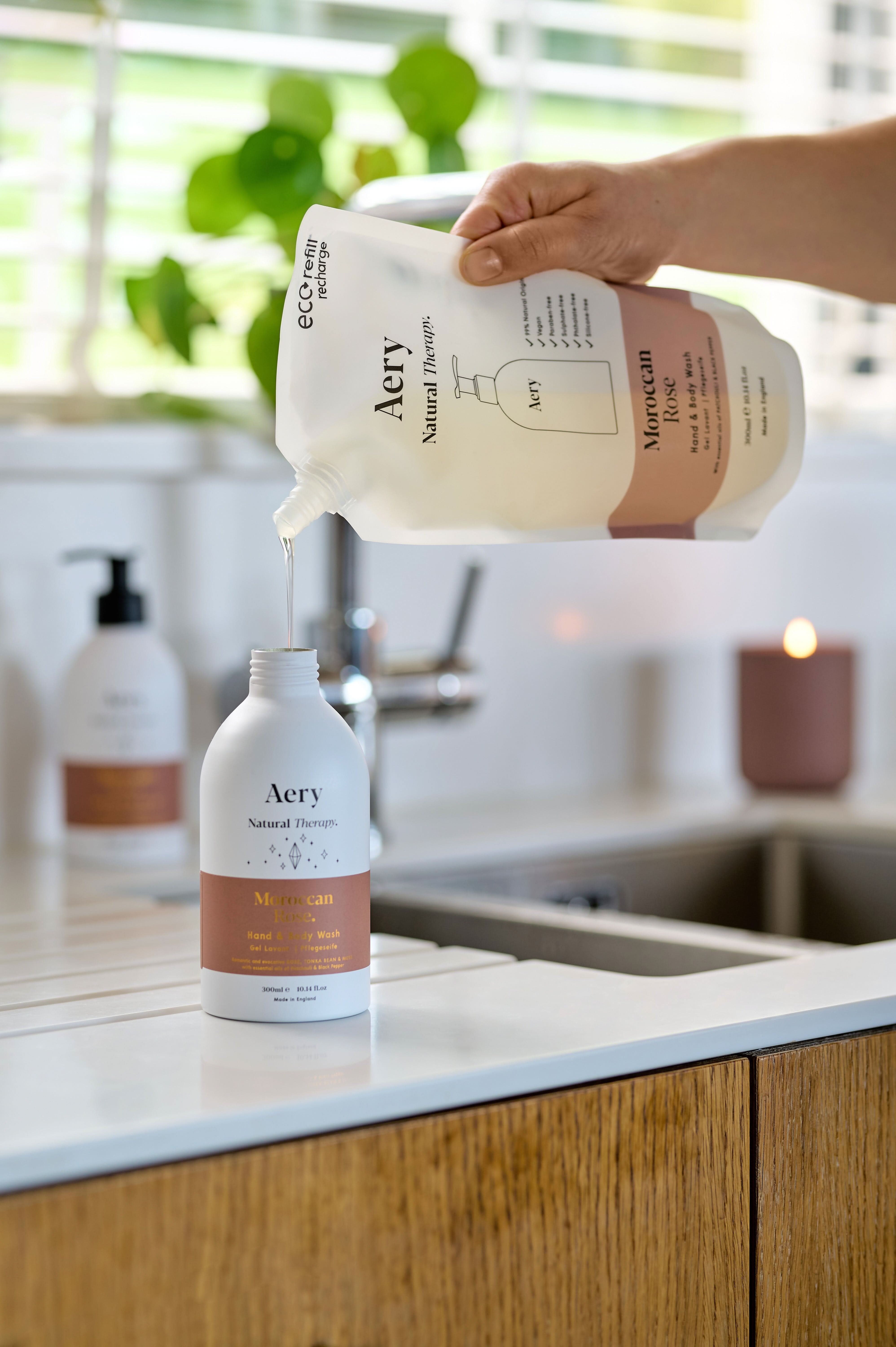 Moroccan Rose hand and body refilll pouch being poured into aery bottle