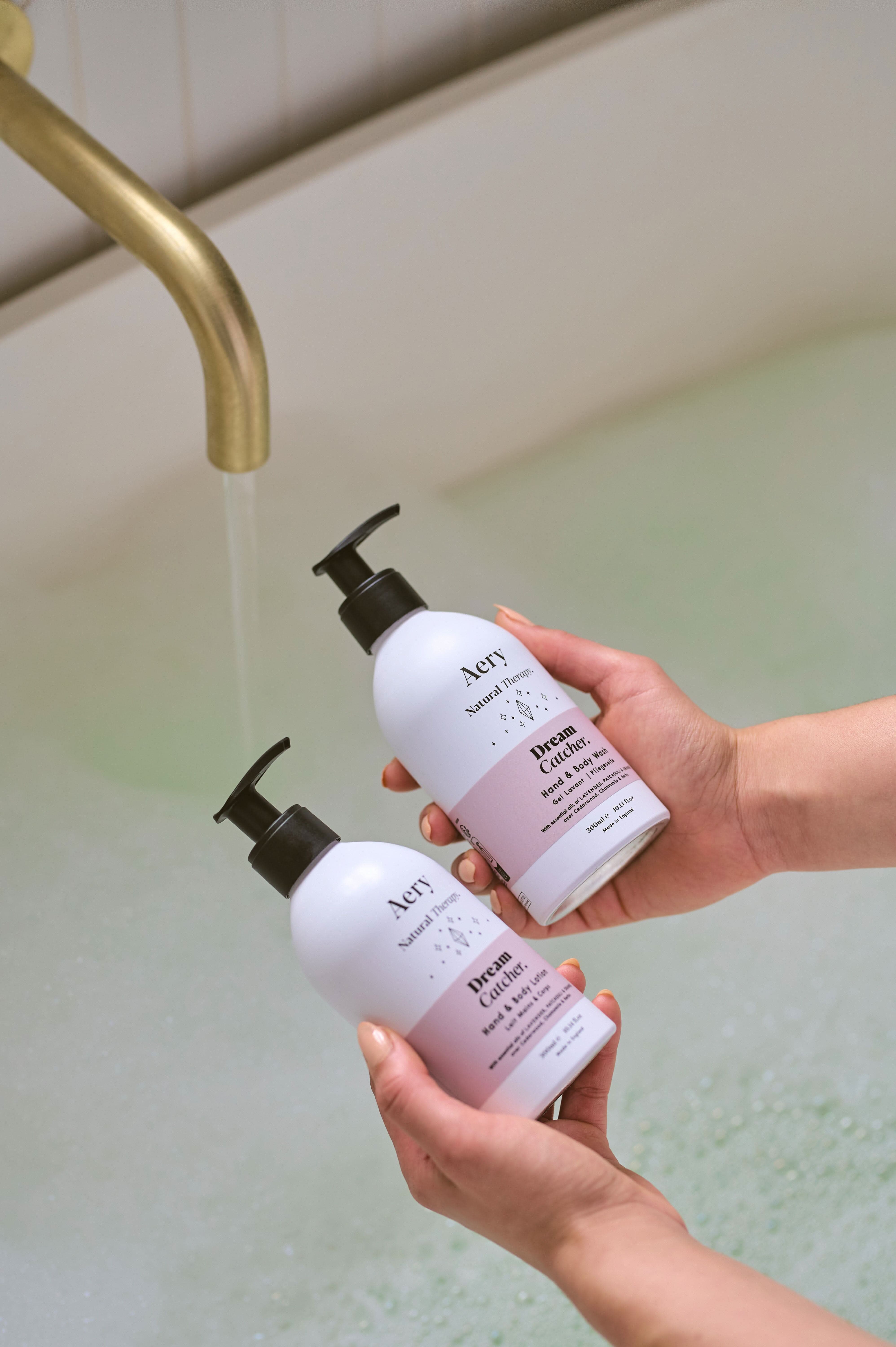 Lilac Dream Catcher Hand and Body Lotion and wash duo by Aery displayed in hands over bubble bath