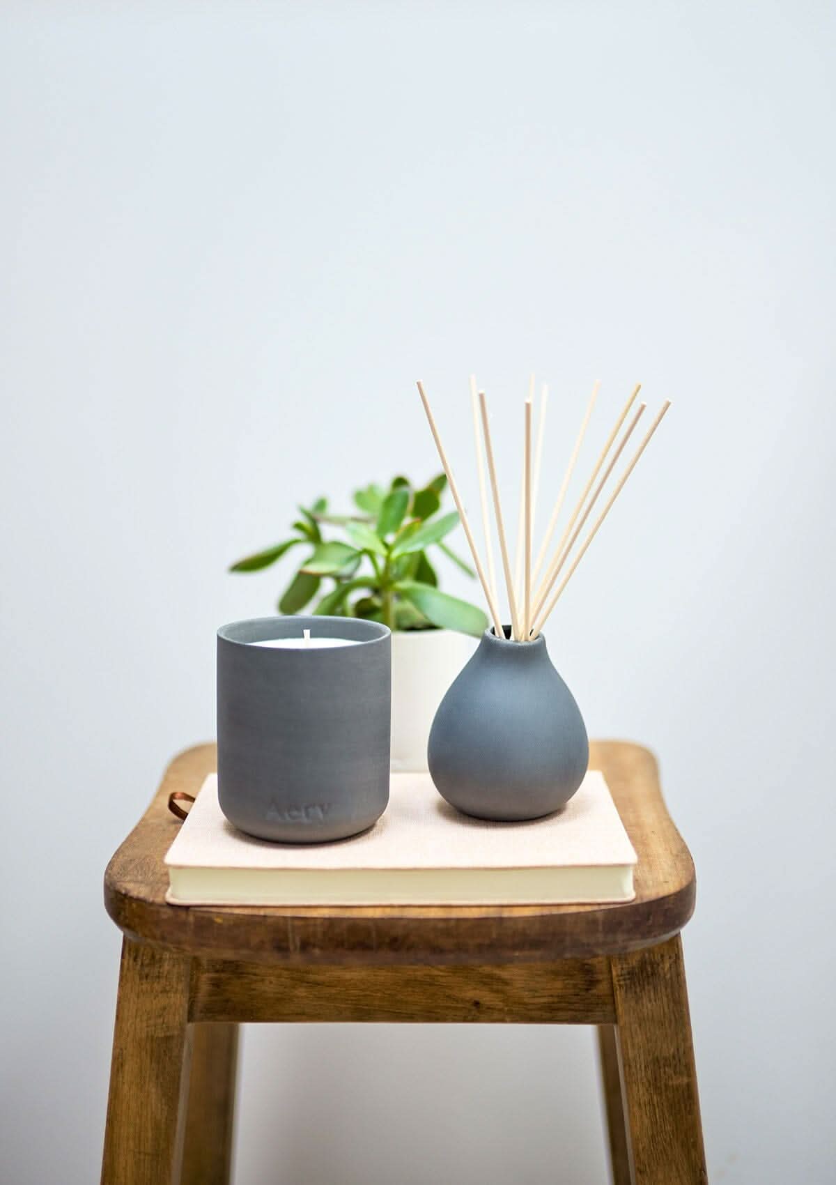 Black Indian Sandalwood diffuser by Aery displayed next to Indian Sandalwood candle placed on wooden stall