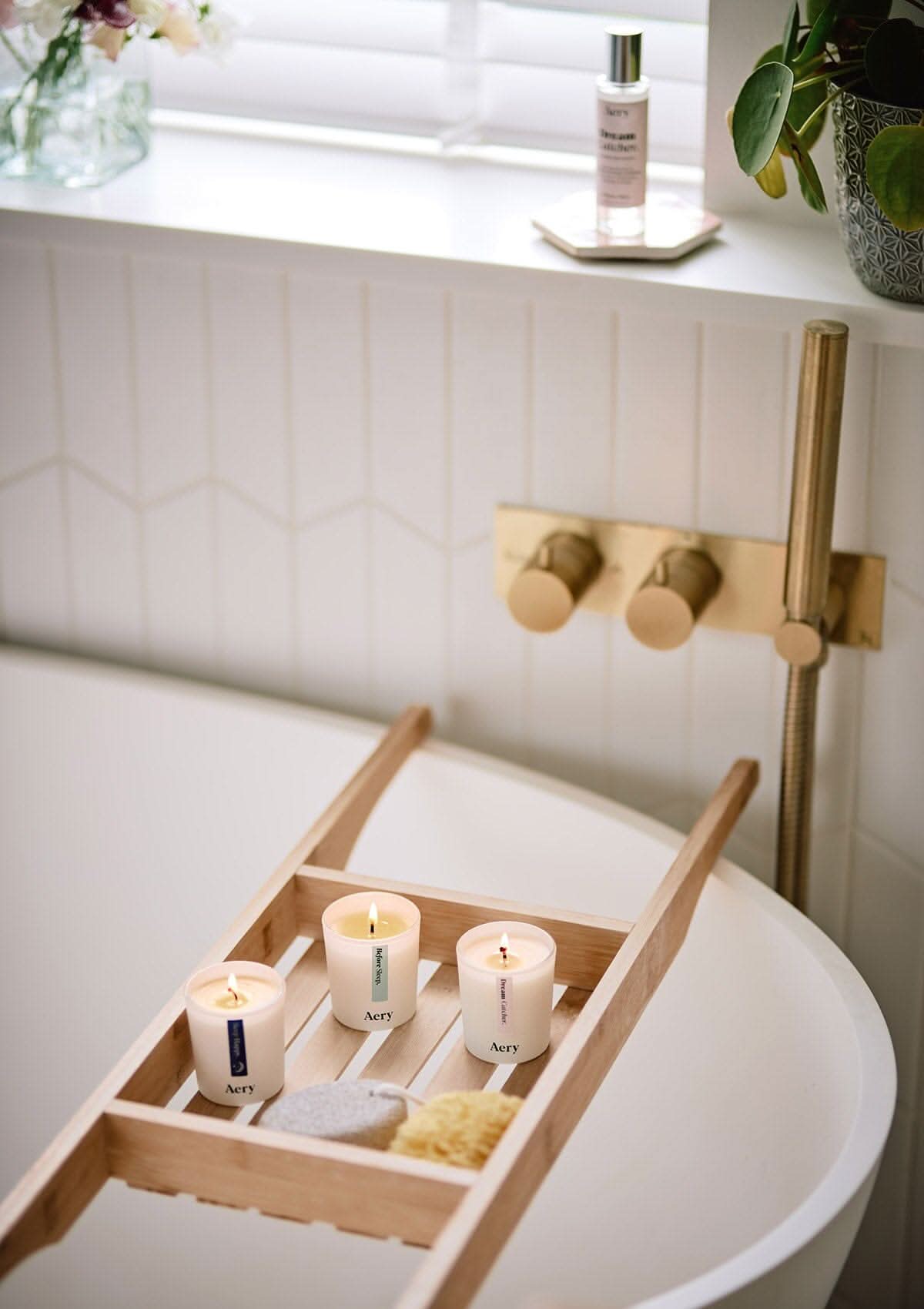Sleep Happy set of three candles by Aery displayed on wooden bath tray In bathroom