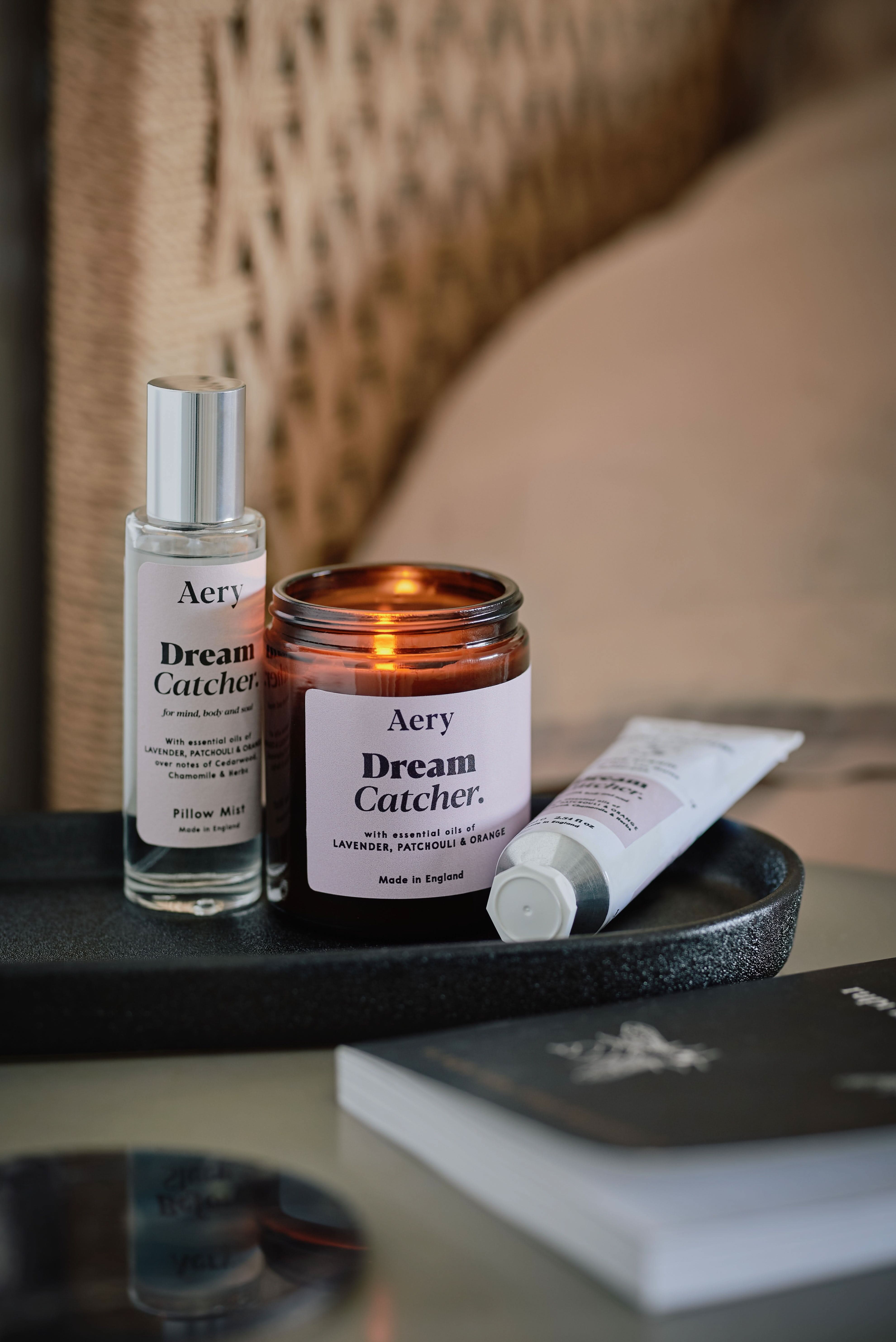 Lilac Dream Catcher jar candle by Aery displayed next to Dream Catcher room mist and hand cream on black tray place on bedside table