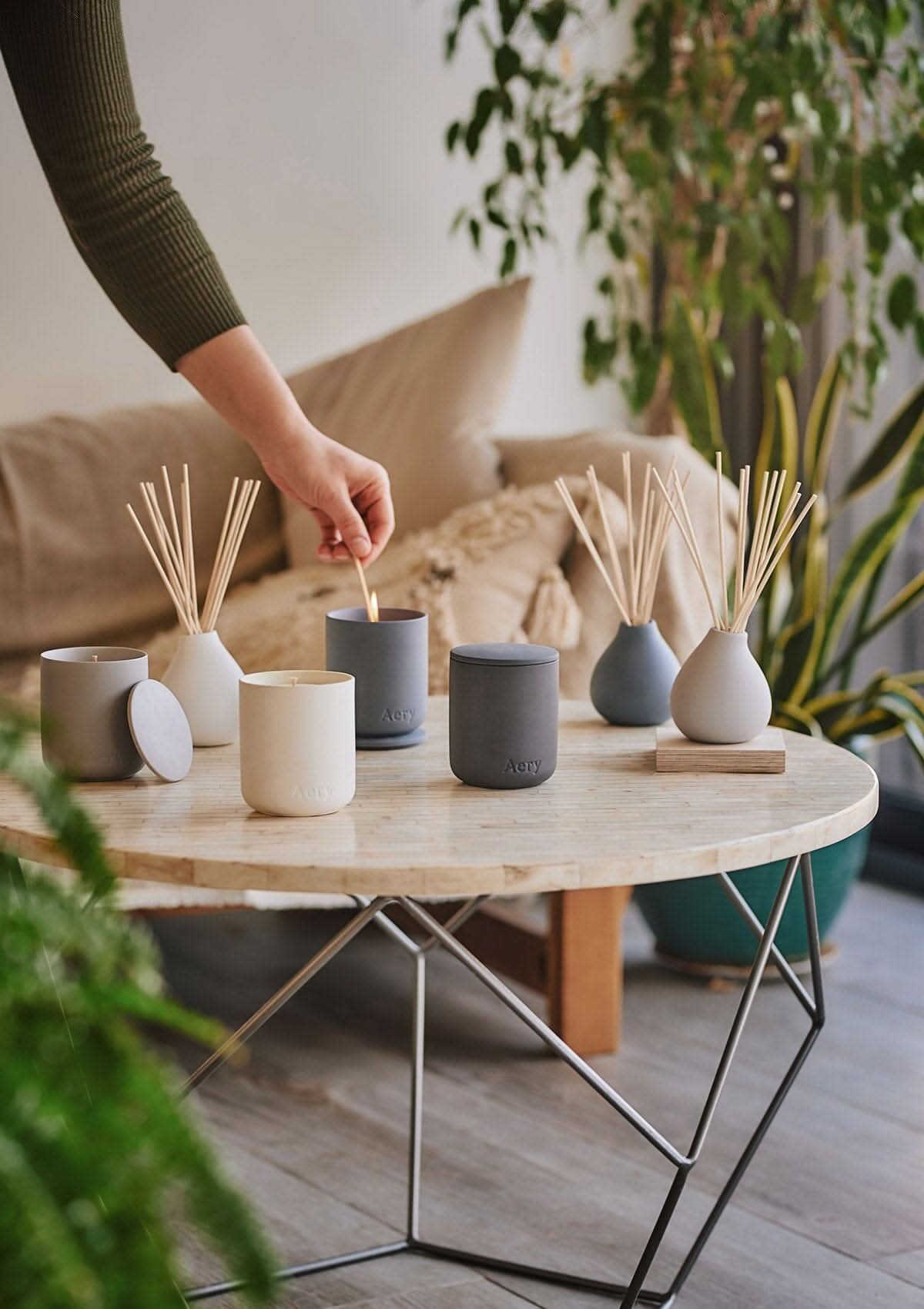 Collection of Fernweh diffuser and candles by Aery displayed on cream round table in kitchen