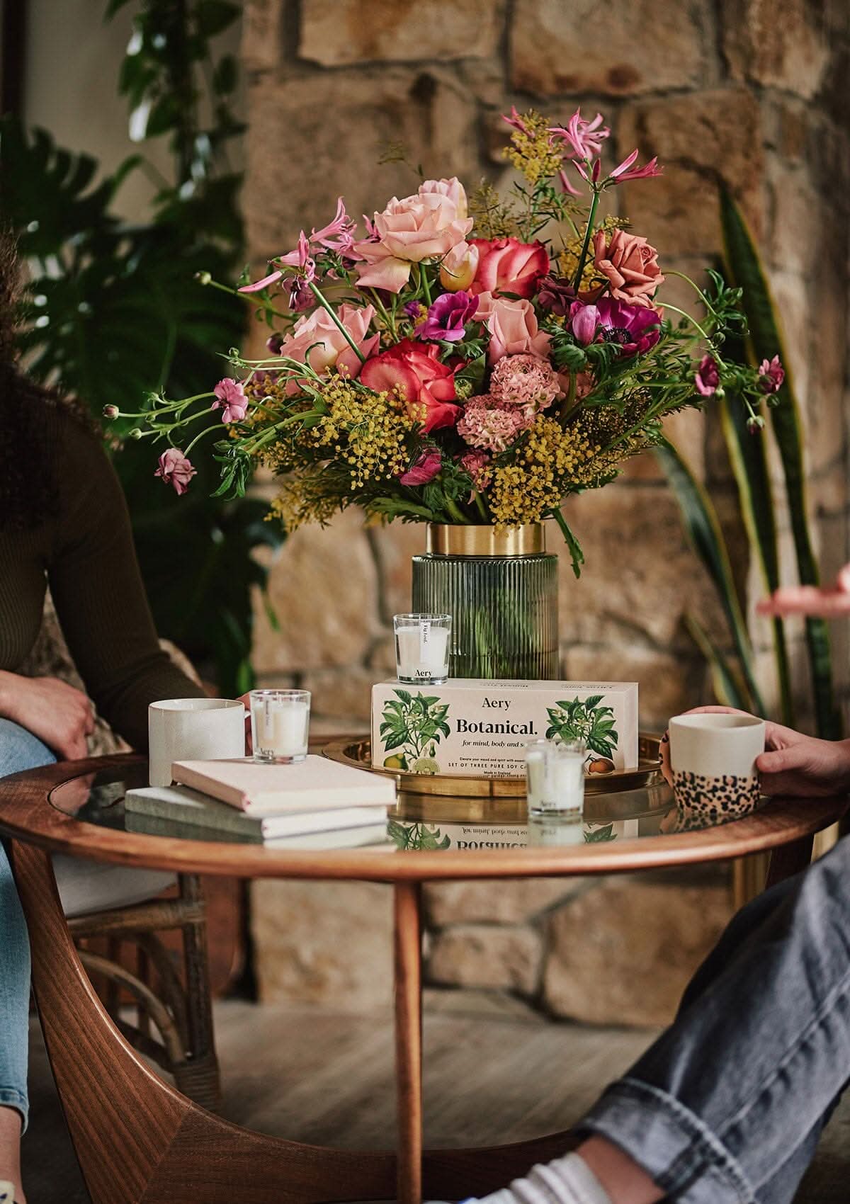 Botanical gift set of three candles by aery displayed next to vase of pink flowers placed on glass table