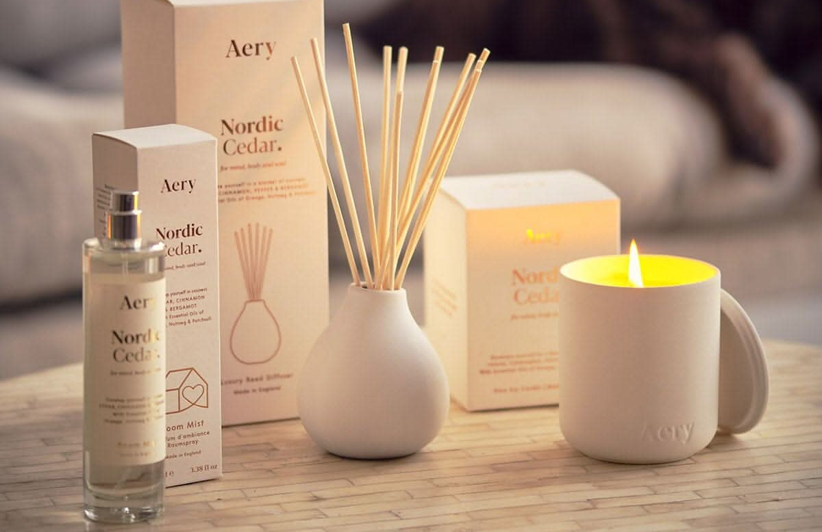 Nordic Cedar diffuser set with candle and reed sticks on a wooden surface.