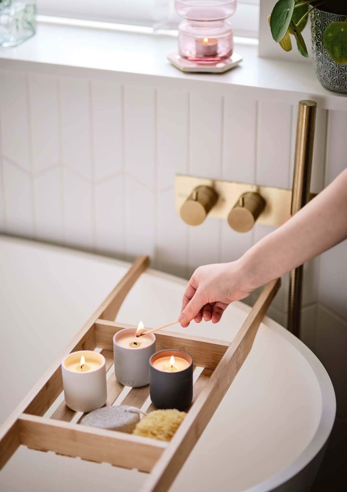 Wonderland gift set of three candles by aery displayed next on wooden bath tray sat over bath