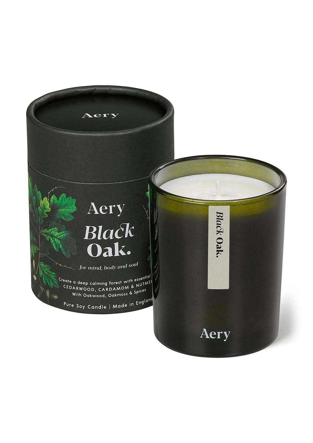 Green Black Oak glass scented candle displayed next to product packaging on white bacground