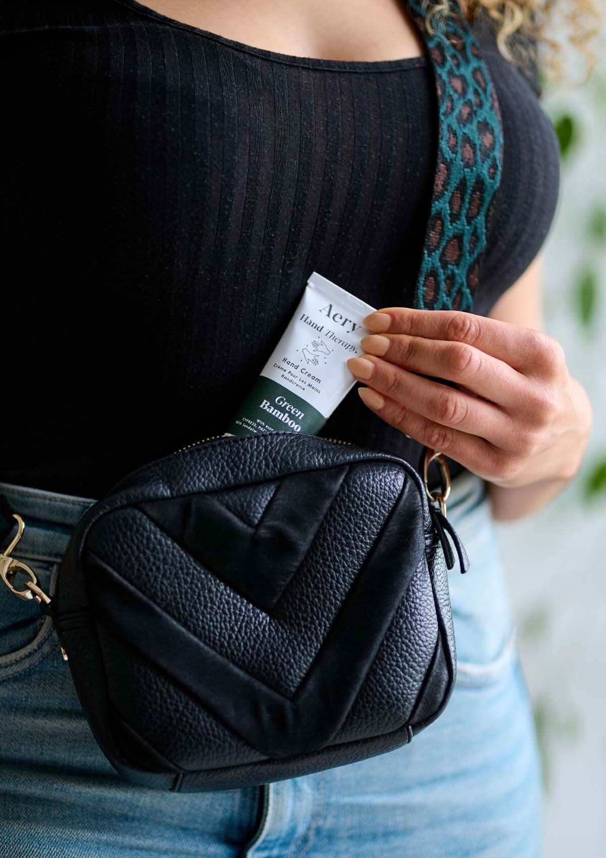Green Bamboo hand cream by Aery displayed in bag being pulled out by hand