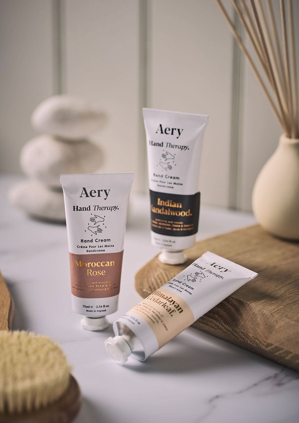 Black Indian Sandalwood hand cream by Aery displayed next to Moroccan rose hand cream and Himalayan Cedarleaf hand cream placed in bathroom