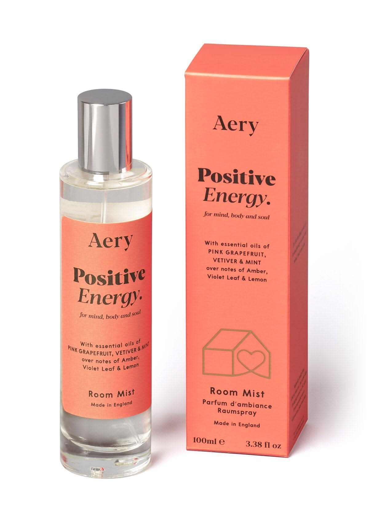 Orange Positive Energy room mist displayed next to product packaging on white bacground