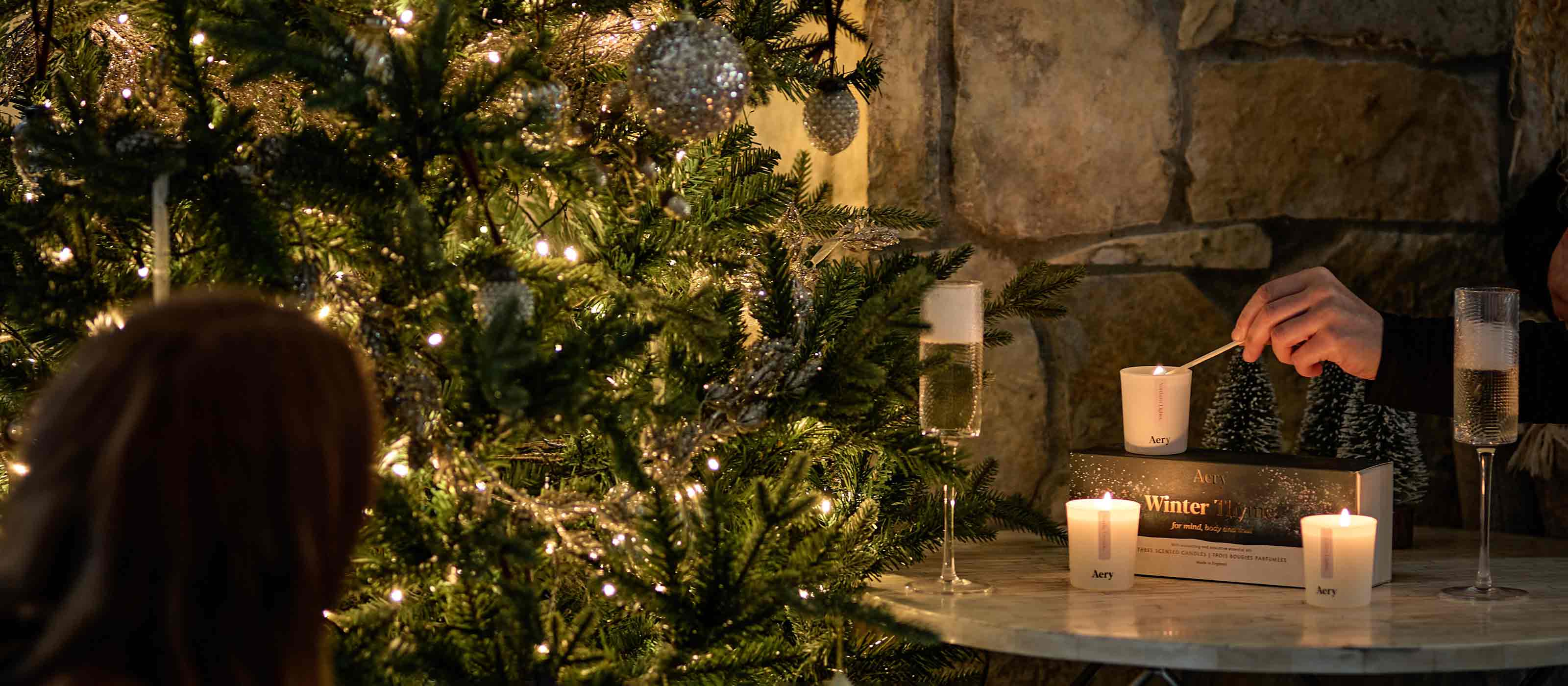 social setting with drinks and candles next to christmas tree