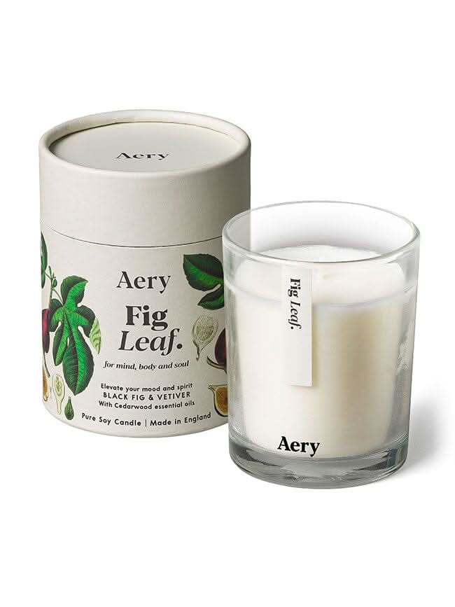Cream Fig Leaf candle by aery displayed next to product packaging on white bacground