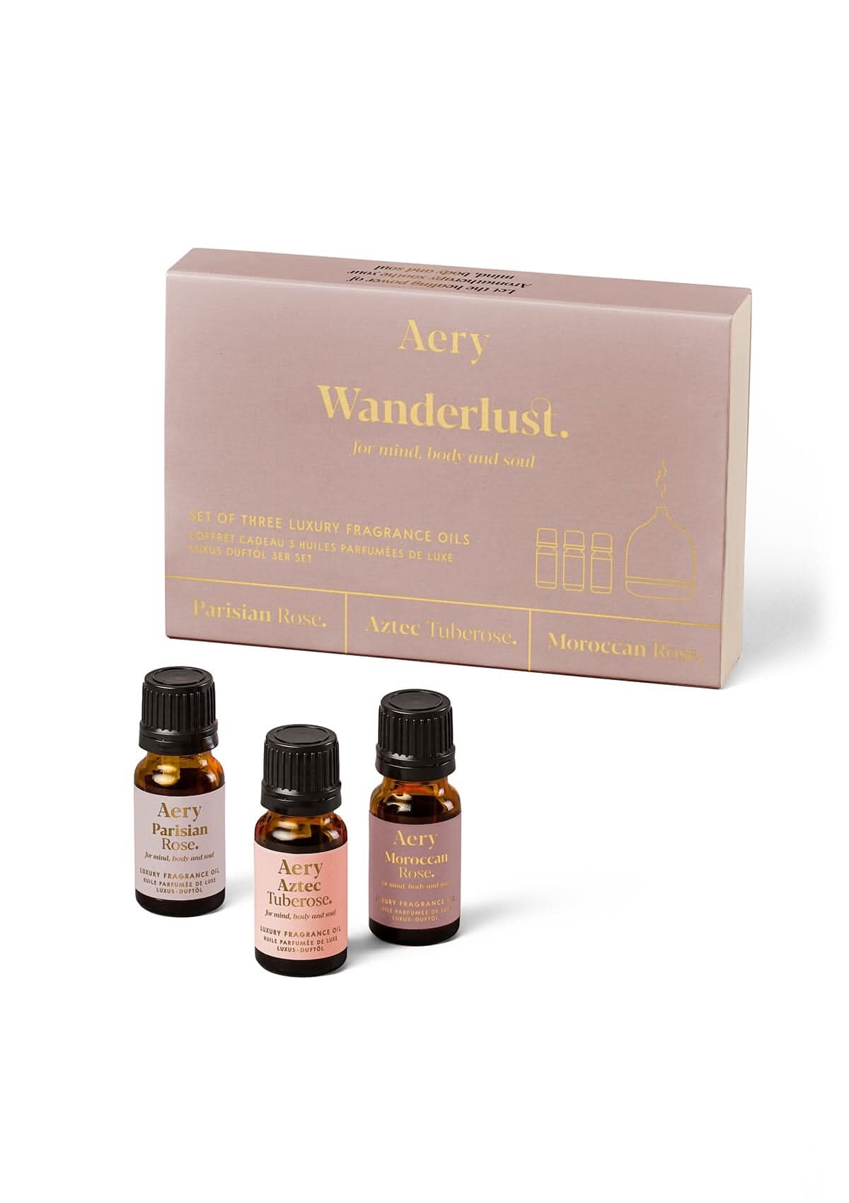 Pink Wanderlust fragrance oil set of three displayed next to product packaging by Aery on white background