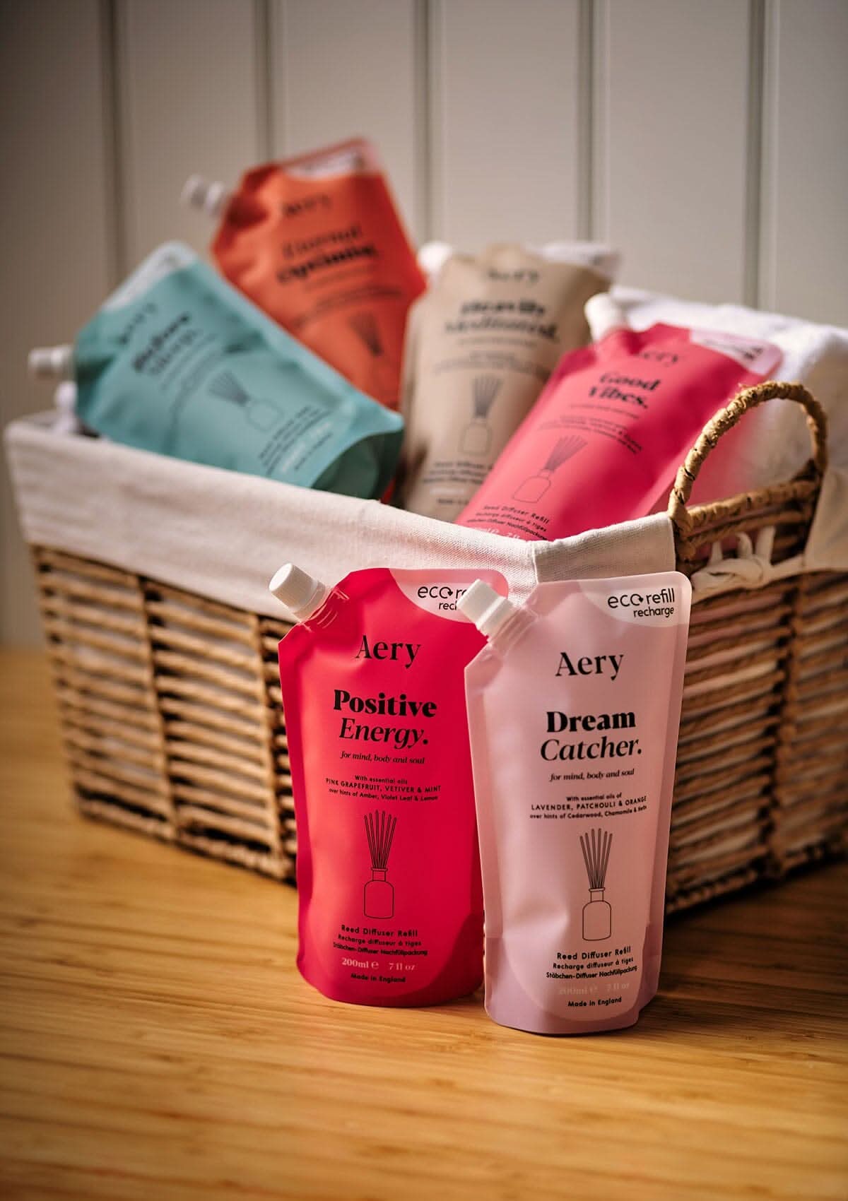 Collection of Aromatherapy reed diffuser refill pouches by aery displayed in wicker basket
