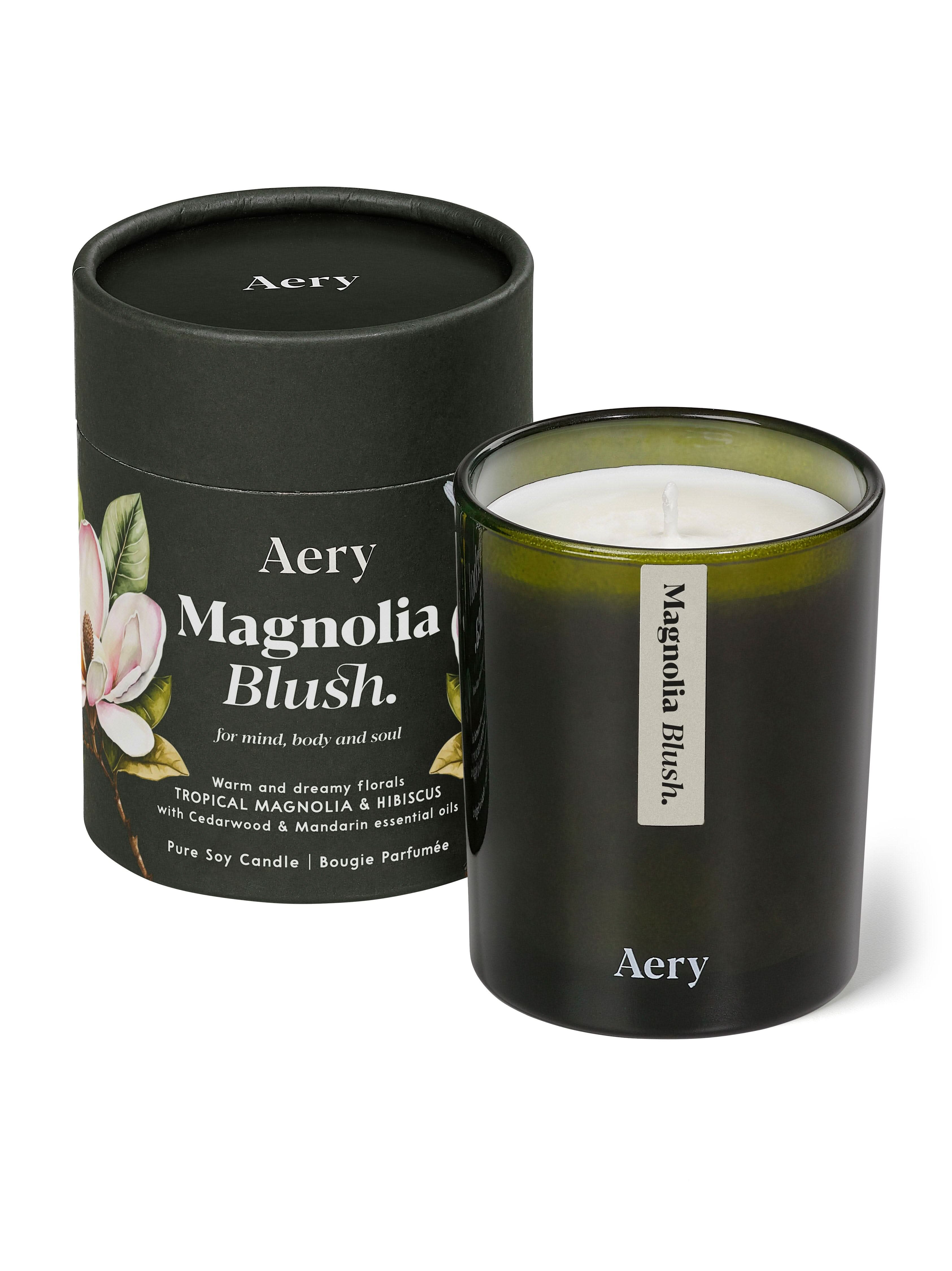 Magnolia Blush candle by aery displayed next to product packaging on white bacground