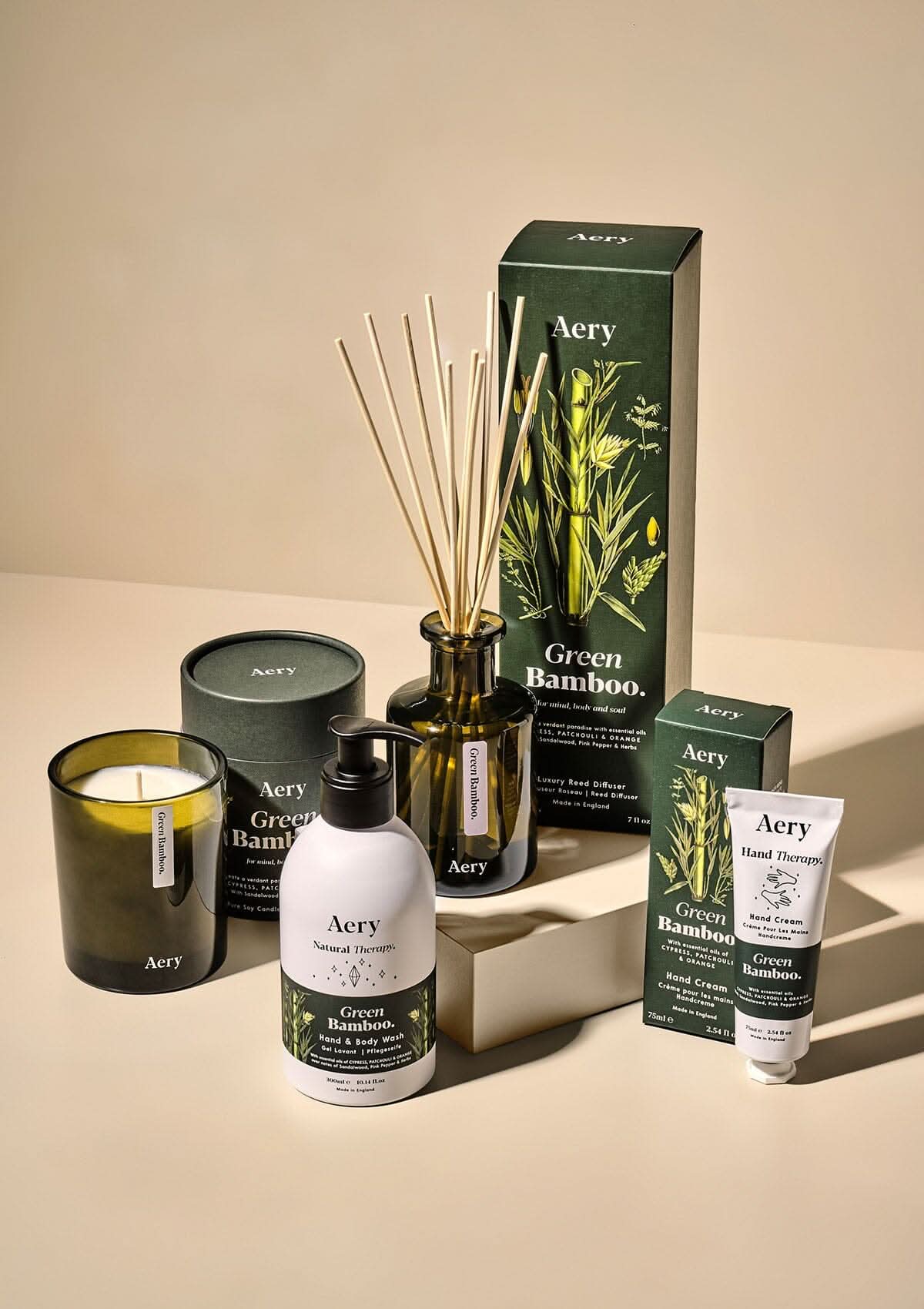 Green Bamboo diffuser, candle, hand cream and lotion by Aery displayed on cream background