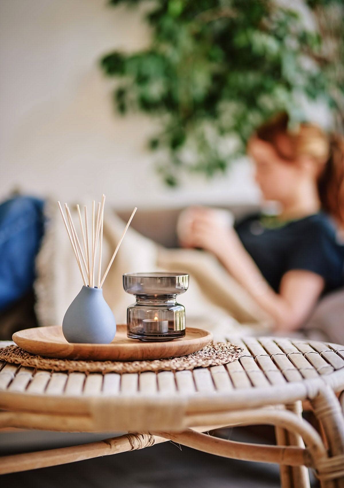 Blue Japanese Garden diffuser by Aery displayed next to black tea light holder on round wooden table in kitchen