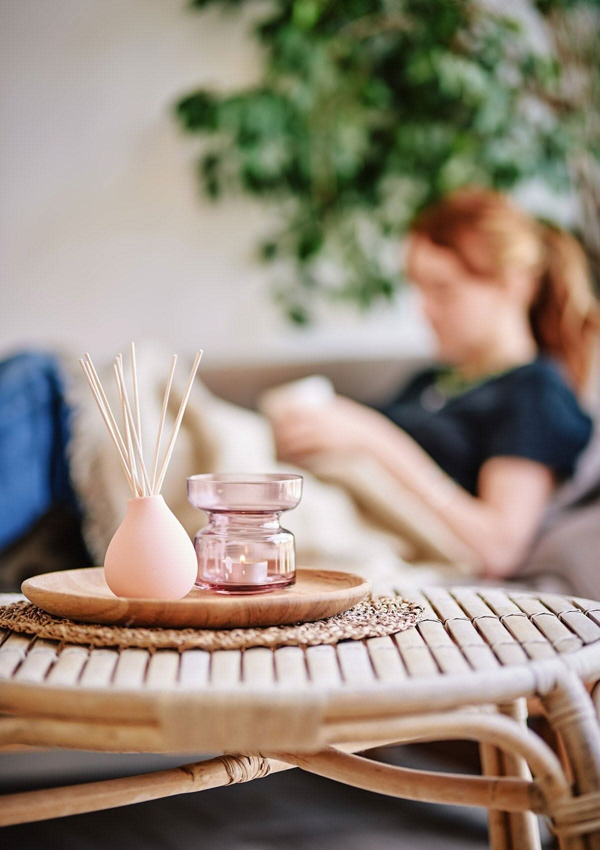 Peach Aztec Tuberose diffuser by Aery displayed next to glass tea light holder on wooden circle table