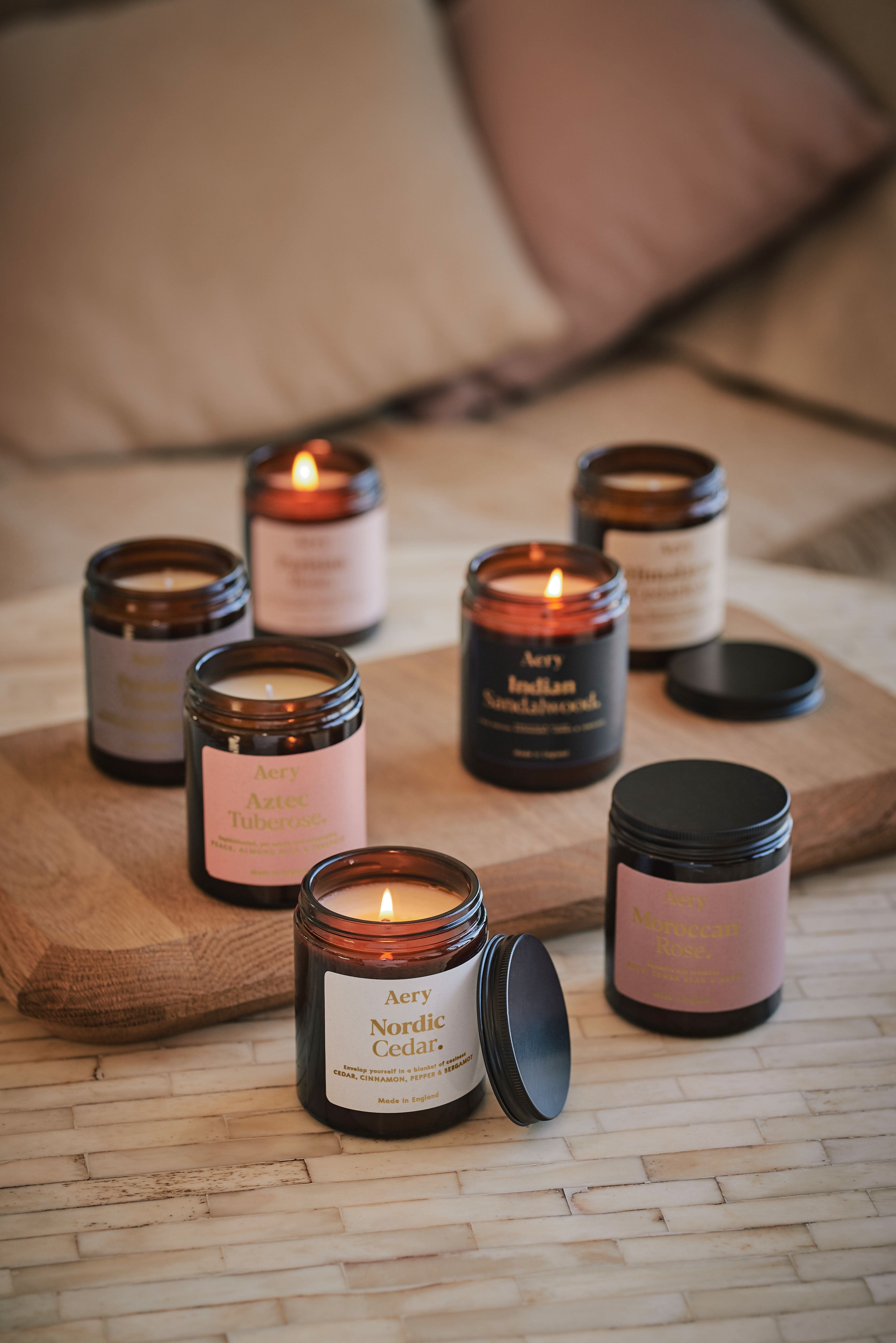 Collection of Fernweh Jar candles by Aery displayed on a wooden table and circle table
