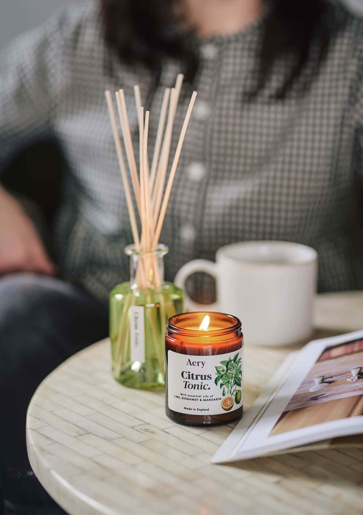 Citrus Tonic jar candle by aery displayed next to citrus tonic diffuser by aery on cream white table