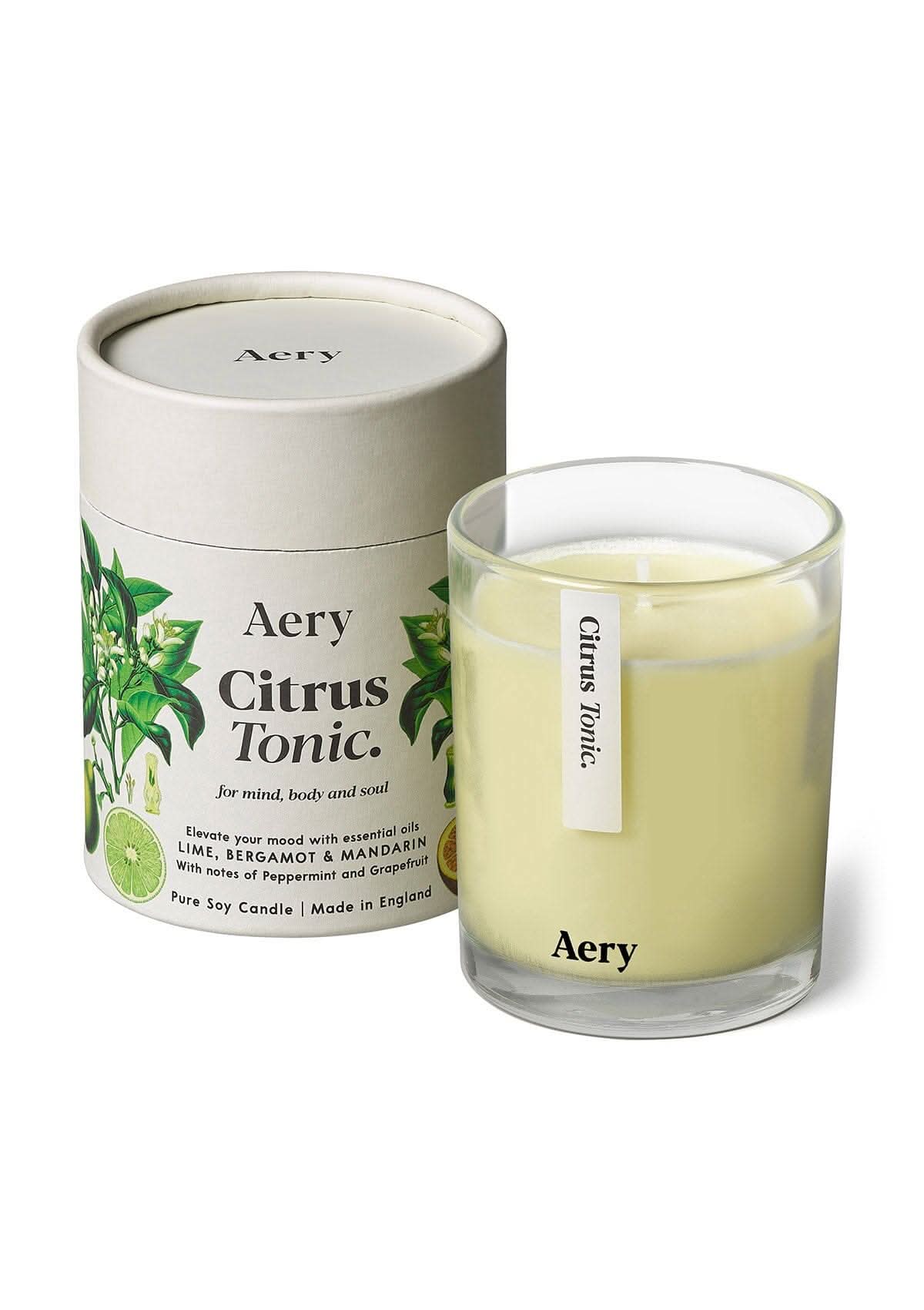 Cream Citrus Tonic glass scented candle displayed next to product packaging on white bacground