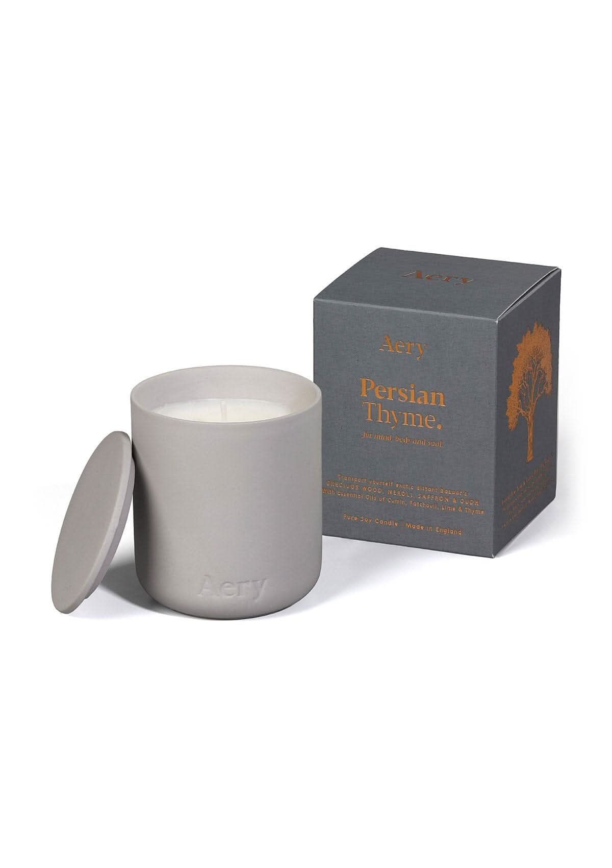 Grey ceramic Persian Thyme scented candle displayed next to product packaging by Aery on white bacground